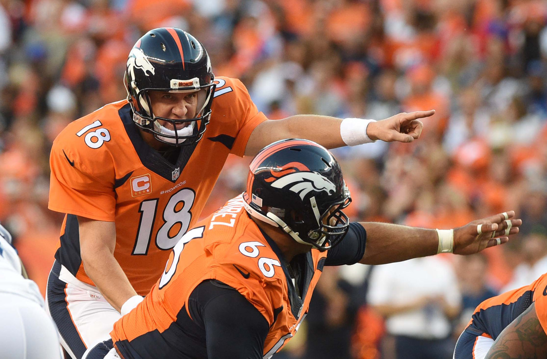 Broncos center Manny Ramirez takes direction from quarterback Peyton Manning during the first quarter of a game against the Indianapolis Colts. The Denver Broncos played the Indianapolis Colts in the season opener on Sunday, Sept. 7, 2014 at Sports Authority Field at Mile High.(The Gazette/Jerilee Bennett)